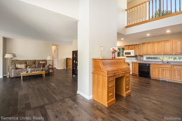 400 E Schafer Rd, Pinckney, MI 48169 - kitchen with white appliances, a towering ceiling, dark wood-type flooring, open floor plan, and healthy amount of natural light