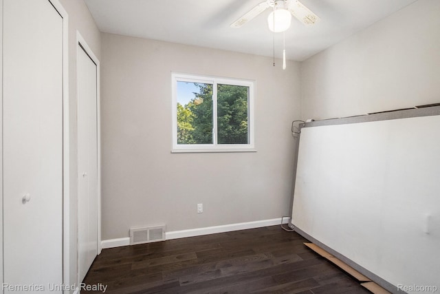 400 E Schafer Rd, Pinckney, MI 48169 - unfurnished bedroom featuring dark wood-style floors and a ceiling fan