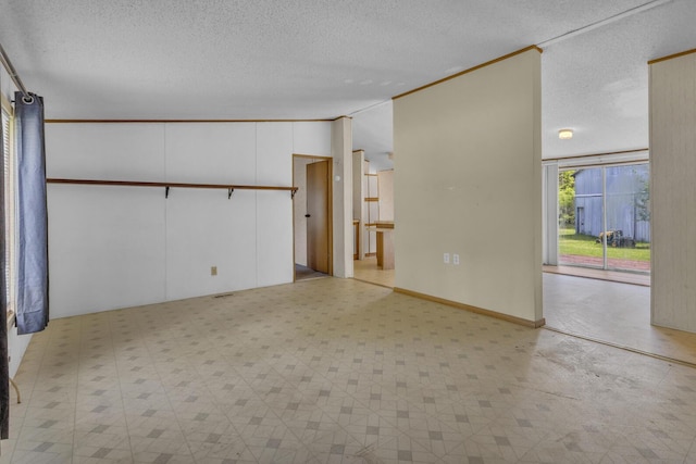 3749 Wellman Rd, Parma, MI 49269 - spare room with light floors, a textured ceiling, vaulted ceiling, and ornamental molding