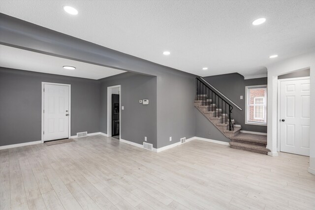 15770 Mansfield St, Detroit, MI 48227 - unfurnished living room with stairs, baseboards, light wood-type flooring, a textured ceiling, and recessed lighting
