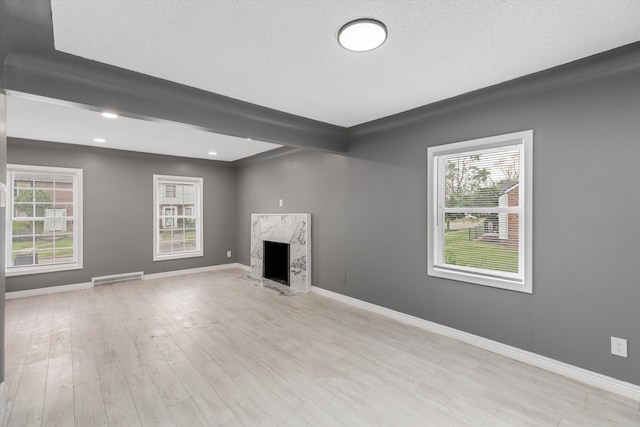 15770 Mansfield St, Detroit, MI 48227 - unfurnished living room with plenty of natural light, a high end fireplace, baseboards, and a textured ceiling