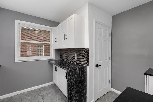 15770 Mansfield St, Detroit, MI 48227 - kitchen featuring baseboards, white cabinets, light marble finish floors, dark stone countertops, and backsplash