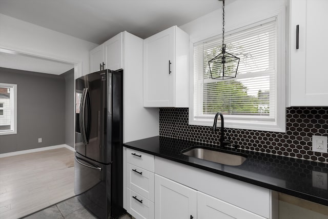 15770 Mansfield St, Detroit, MI 48227 - kitchen featuring black fridge with ice dispenser, a sink, dark countertops, and white cabinetry