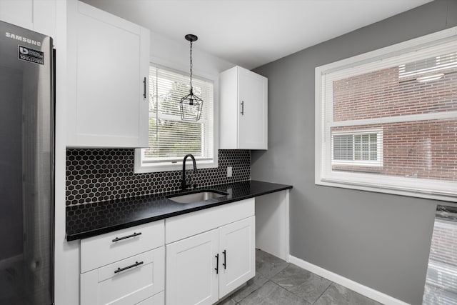 15770 Mansfield St, Detroit, MI 48227 - kitchen with a sink, freestanding refrigerator, dark countertops, and white cabinets