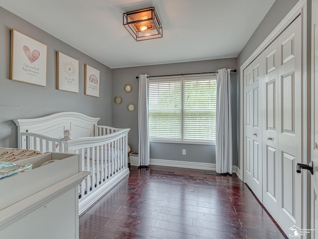 469 Corinth Cir, Dundee, MI 48131 - bedroom with baseboards, dark wood finished floors, a nursery area, and a closet