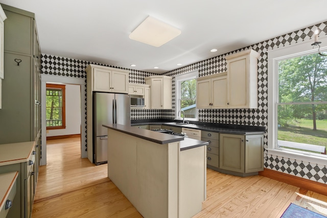 9934 W Fg Ave, Kalamazoo, MI 49009 - kitchen with wallpapered walls, stainless steel appliances, a sink, dark countertops, and light wood-style floors