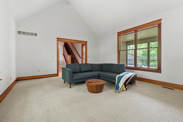 9934 W Fg Ave, Kalamazoo, MI 49009 - carpeted living room with baseboards, stairway, and high vaulted ceiling