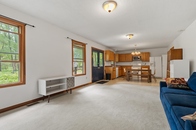 9934 W Fg Ave, Kalamazoo, MI 49009 - living area with light colored carpet, a chandelier, and baseboards