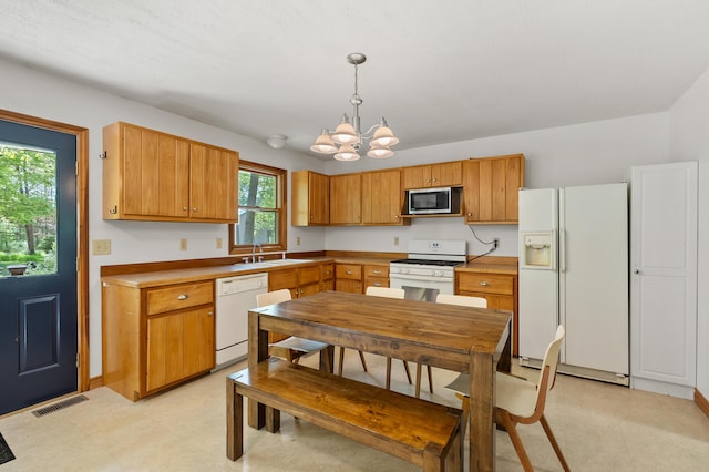 9934 W Fg Ave, Kalamazoo, MI 49009 - kitchen with white appliances, a sink, a chandelier, hanging light fixtures, and light flooring