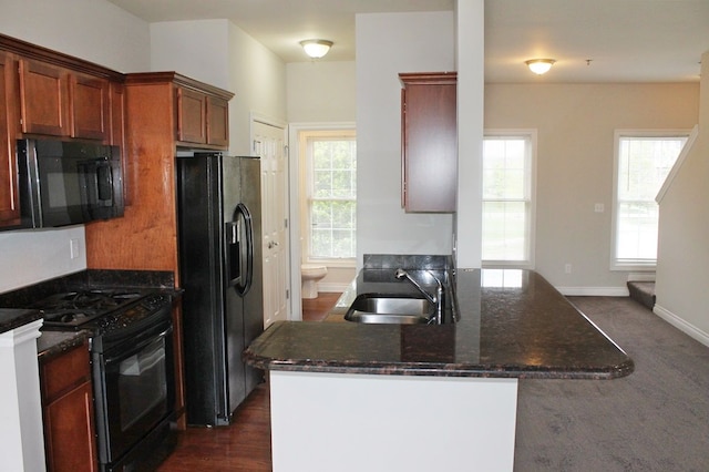 45862 S Stonewood Rd Unit 218, Canton, MI 48187 - kitchen featuring black appliances, a sink, a peninsula, dark stone counters, and baseboards