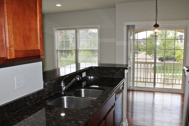 45862 S Stonewood Rd Unit 218, Canton, MI 48187 - kitchen with a sink, dark stone counters, pendant lighting, brown cabinets, and wood finished floors