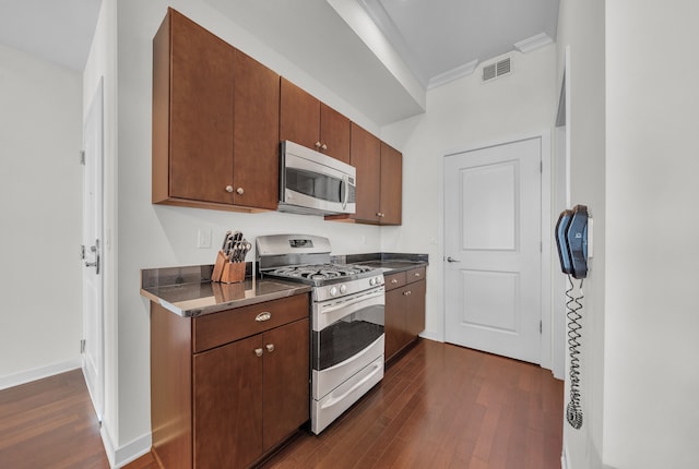1135 Shelby St Unit 59-2808, Detroit, MI 48226 - kitchen featuring appliances with stainless steel finishes, dark wood finished floors, crown molding, dark countertops, and baseboards