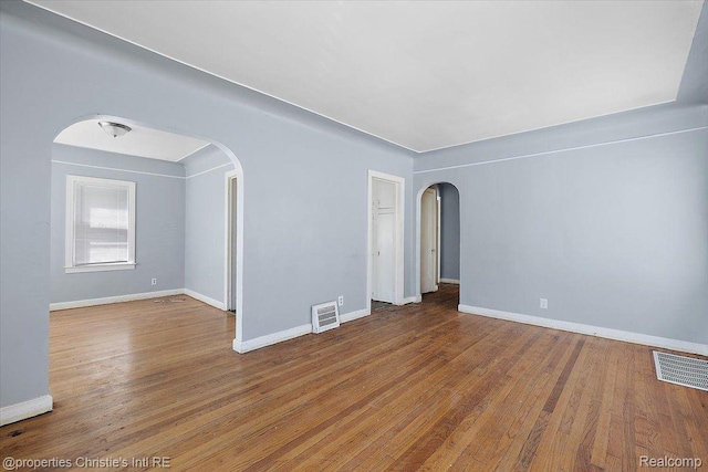 19479 Helen St, Detroit, MI 48234 - unfurnished room featuring arched walkways, wood finished floors, and baseboards