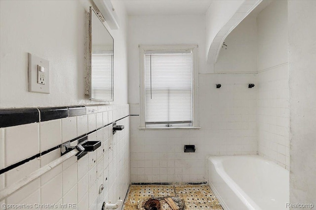 19479 Helen St, Detroit, MI 48234 - bathroom featuring a bath, tile walls, plenty of natural light, and wainscoting