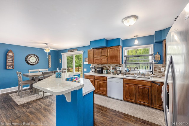6621 Dove Rd, Kimball, MI 48074 - kitchen with dishwasher, freestanding refrigerator, light countertops, a sink, and brown cabinetry