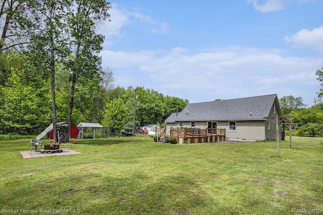 6621 Dove Rd, Kimball, MI 48074 - view of grassy yard with an outdoor fire pit and a wooden deck