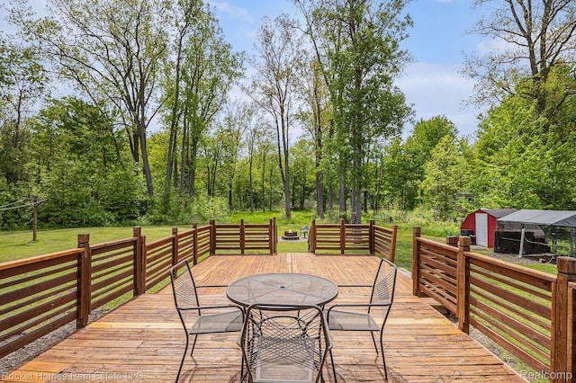 6621 Dove Rd, Kimball, MI 48074 - wooden terrace featuring outdoor dining area, a lawn, and an outdoor structure