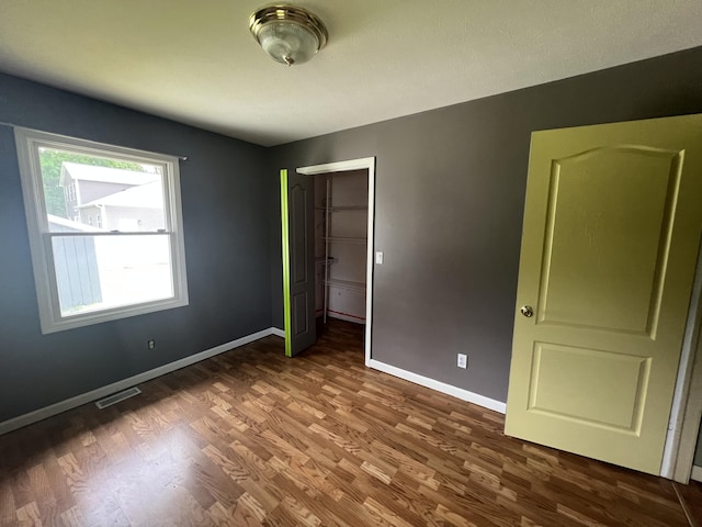 72 E Brink St, Grant, MI 49327 - unfurnished bedroom featuring wood finished floors, baseboards, and a closet