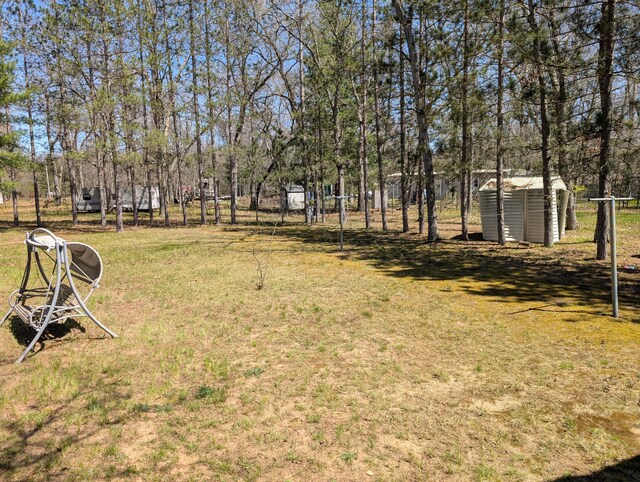 5268 S Arrowhead Trl, Baldwin, MI 49304 - view of green lawn with a shed and an outbuilding