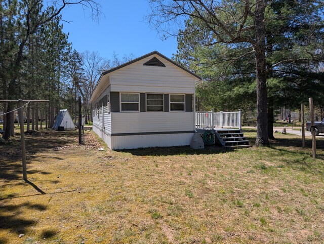 5268 S Arrowhead Trl, Baldwin, MI 49304 - view of front facade featuring a wooden deck and a front lawn