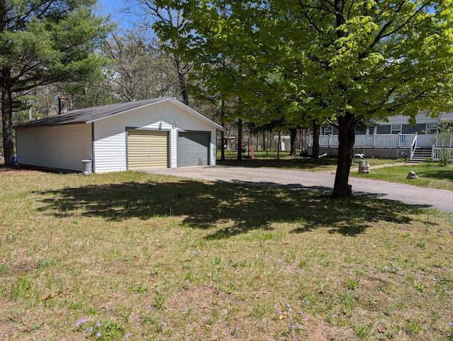 5268 S Arrowhead Trl, Baldwin, MI 49304 - view of home's exterior featuring a detached garage, an outdoor structure, and a lawn