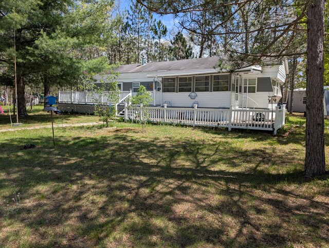 5268 S Arrowhead Trl, Baldwin, MI 49304 - view of front of house featuring a sunroom, a deck, and a front lawn