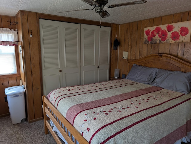 5268 S Arrowhead Trl, Baldwin, MI 49304 - bedroom with a closet, wooden walls, light carpet, and ceiling fan