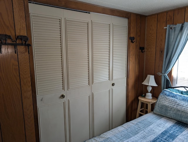 5268 S Arrowhead Trl, Baldwin, MI 49304 - bedroom featuring a closet, a textured ceiling, and wood walls