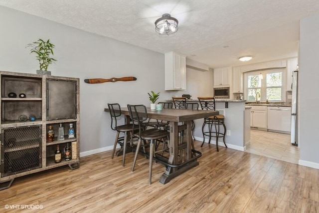2553 Bristol Ter, Saint Joseph, MI 49085 - dining room featuring a textured ceiling, light wood finished floors, and baseboards