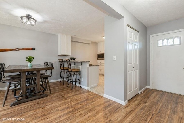 2553 Bristol Ter, Saint Joseph, MI 49085 - dining room with light wood-style floors, baseboards, and a textured ceiling