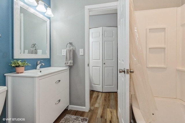 2553 Bristol Ter, Saint Joseph, MI 49085 - bathroom with wood finished floors, vanity, curtained shower, baseboards, and toilet