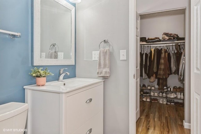 2553 Bristol Ter, Saint Joseph, MI 49085 - bathroom featuring vanity, wood finished floors, toilet, and a spacious closet