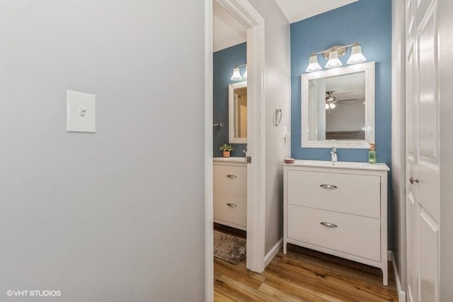 2553 Bristol Ter, Saint Joseph, MI 49085 - half bathroom with wood finished floors, vanity, a ceiling fan, and baseboards