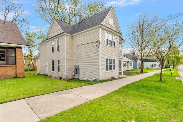 470 Houseman Ave NE, Grand Rapids, MI 49503 - view of side of home with a lawn, a chimney, and roof with shingles