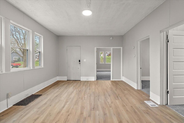 470 Houseman Ave NE, Grand Rapids, MI 49503 - foyer entrance featuring light wood-type flooring, a textured ceiling, and baseboards