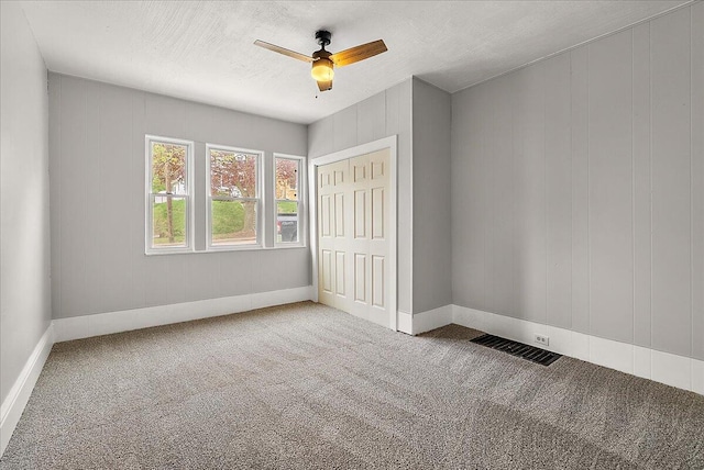 470 Houseman Ave NE, Grand Rapids, MI 49503 - unfurnished bedroom with carpet, baseboards, a closet, ceiling fan, and a textured ceiling