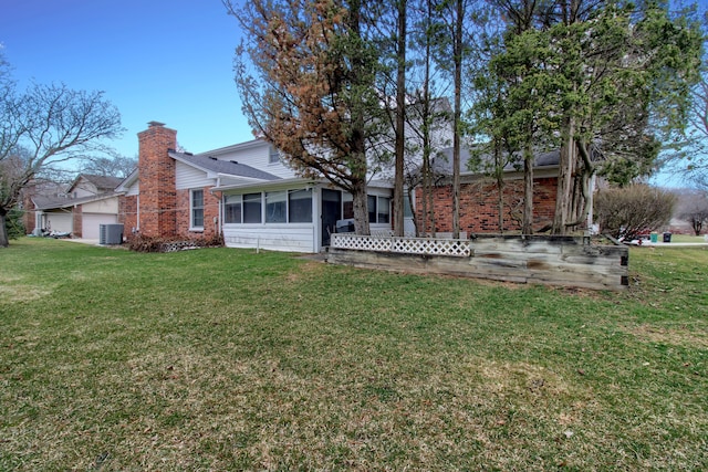 33951 Old Timber Rd, Farmington Hills, MI 48331 - rear view of house featuring brick siding, a sunroom, a lawn, and a chimney