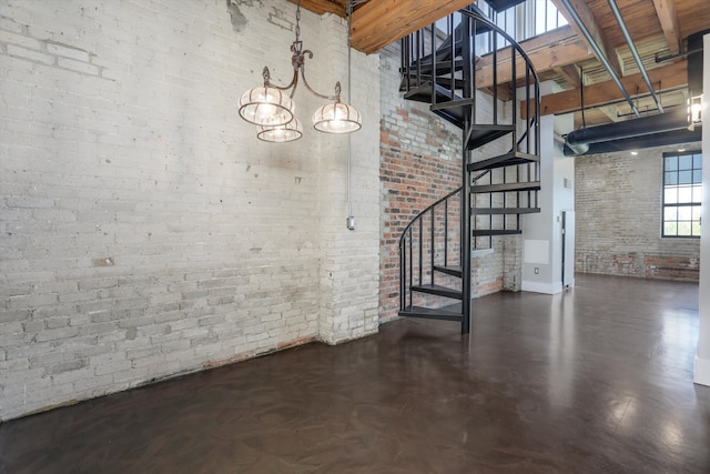 6533 E Jefferson Ave Unit 413W, Detroit, MI 48207 - below grade area featuring brick wall, baseboards, stairway, and a chandelier