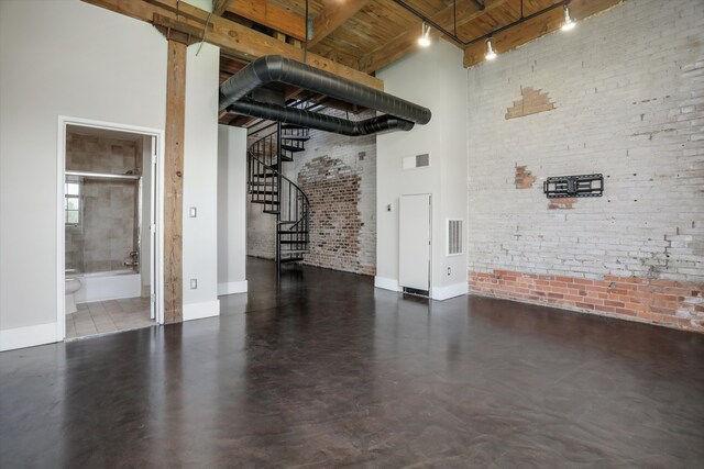 6533 E Jefferson Ave Unit 413W, Detroit, MI 48207 - below grade area featuring stairway, brick wall, rail lighting, wooden ceiling, and baseboards