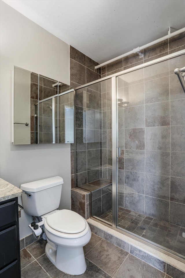 6533 E Jefferson Ave Unit 413W, Detroit, MI 48207 - bathroom featuring a stall shower, vanity, toilet, and tile patterned flooring