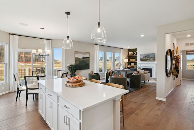 27106 Gallop Way, Saline, MI 48176 - kitchen with a center island, white cabinetry, light wood-type flooring, a breakfast bar, and light countertops