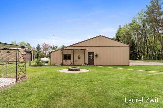 1442 W Tyler Rd, Hart, MI 49420 - back of house with a lawn, a fire pit, a pole building, and an outbuilding