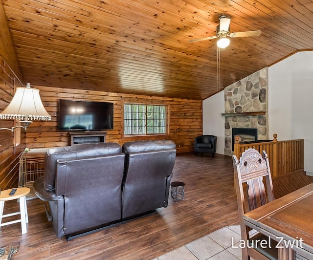 1442 W Tyler Rd, Hart, MI 49420 - living room with lofted ceiling, wood ceiling, ceiling fan, a stone fireplace, and wood walls