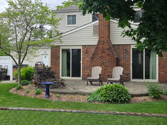 rear view of house featuring a patio area and brick siding