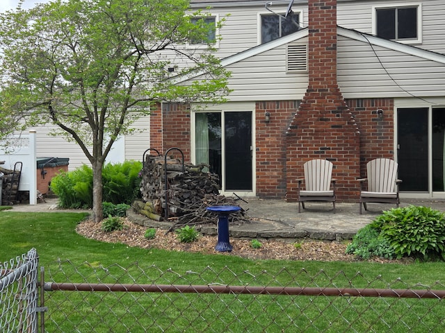 rear view of property with brick siding and a patio area