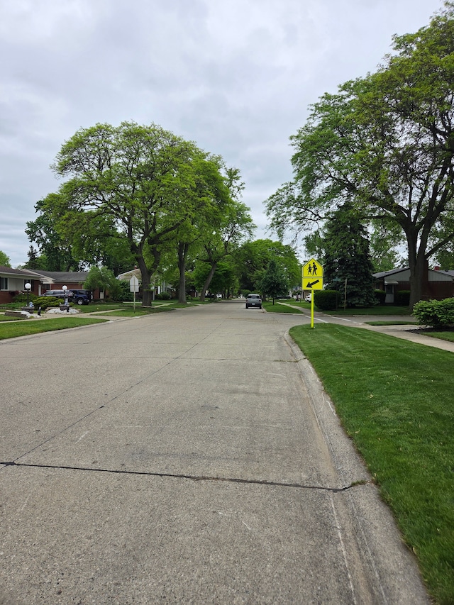 view of concrete street featuring traffic signs and curbs