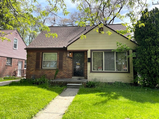 19400 Greydale Ave, Detroit, MI 48219 - view of front of house featuring a front yard, a shingled roof, and brick siding