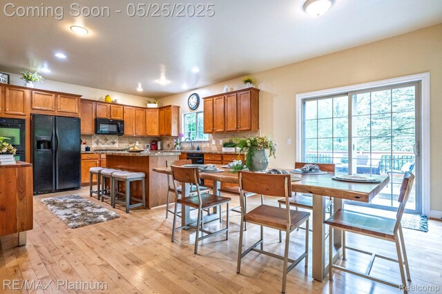 2038 Pine Bluffs Ct, Highland, MI 48357 - kitchen with black appliances, brown cabinets, backsplash, light wood-style floors, and recessed lighting