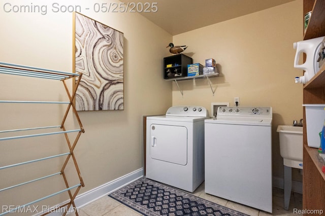 2038 Pine Bluffs Ct, Highland, MI 48357 - washroom with separate washer and dryer, light tile patterned flooring, and baseboards