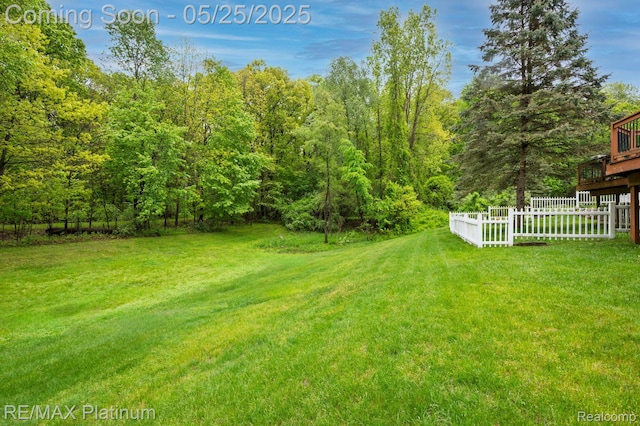 2038 Pine Bluffs Ct, Highland, MI 48357 - view of yard featuring a deck and a wooded view